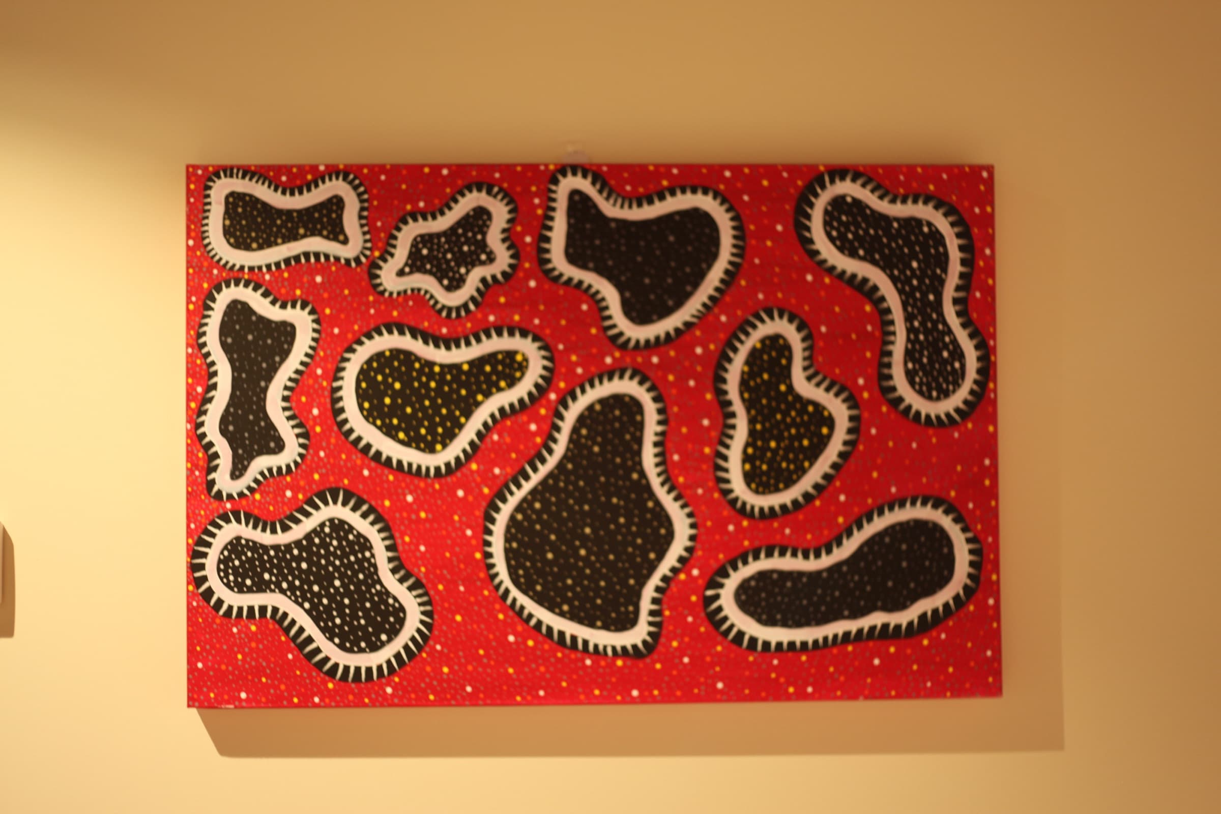 A red and black dot painting on a feature wall