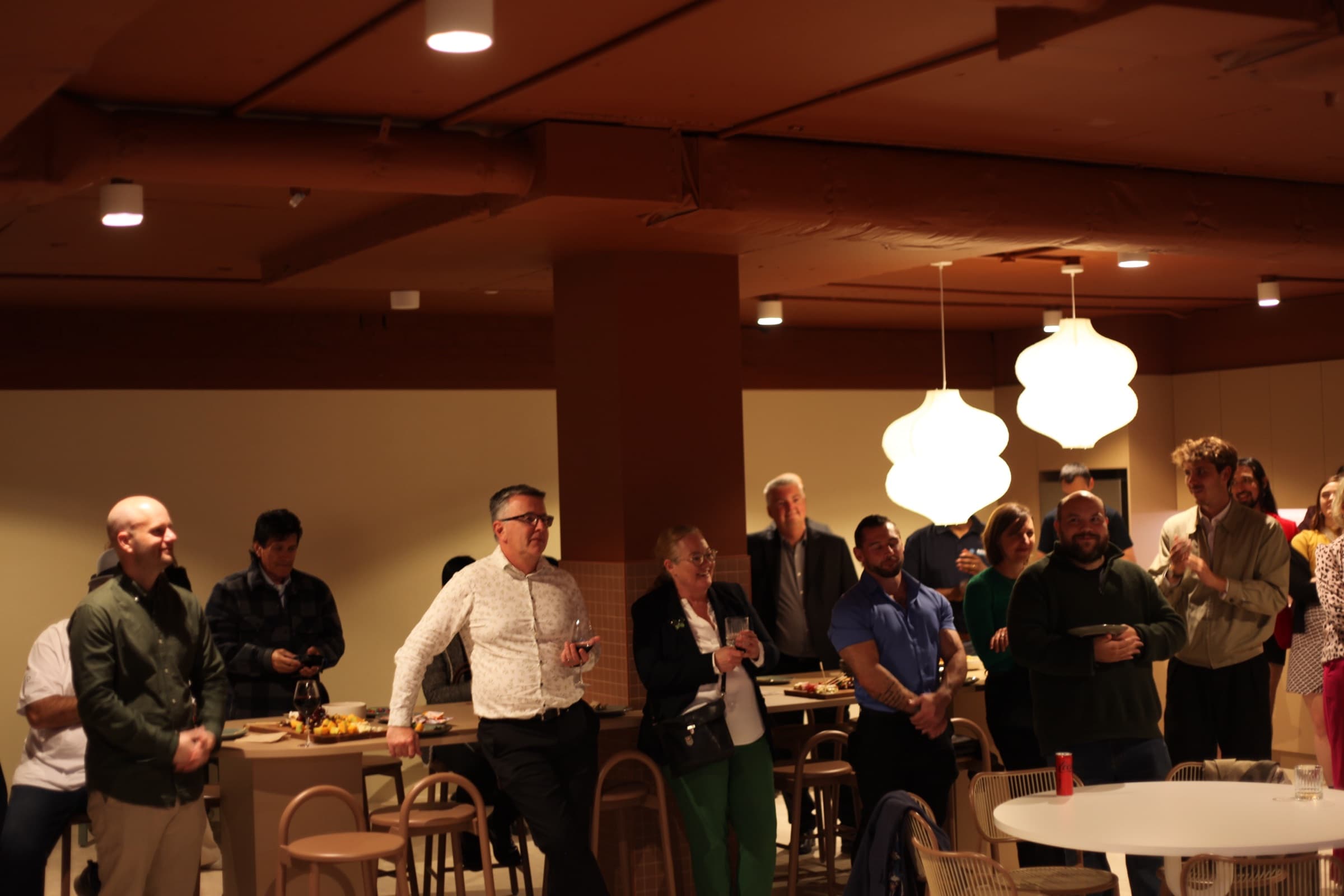 Guests gathered under pendant lights at a launch night in the space
