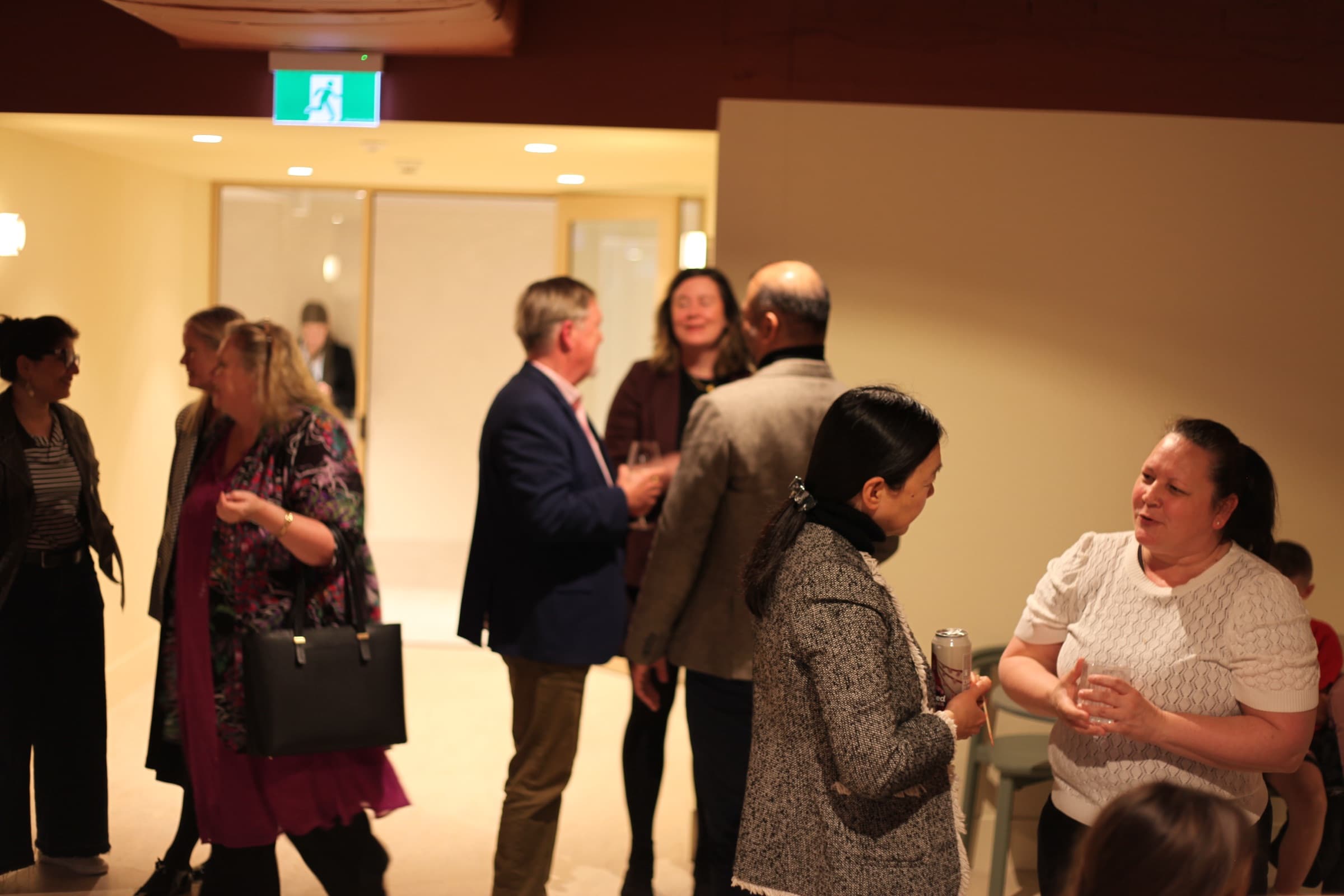 Guests chatting in small groups at a launch night