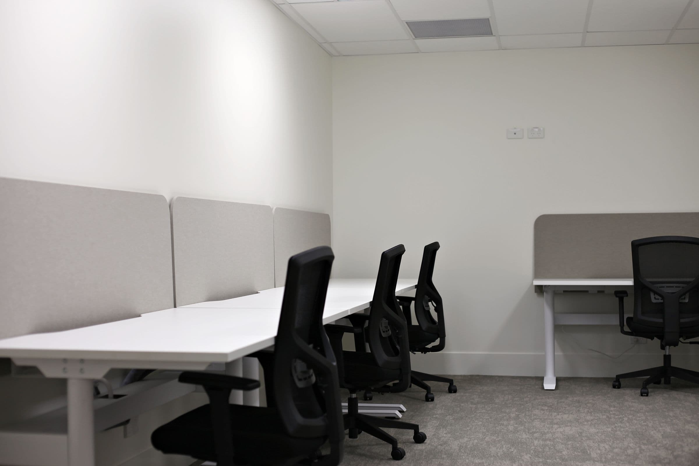 Desks with grey screen dividers in a bright room