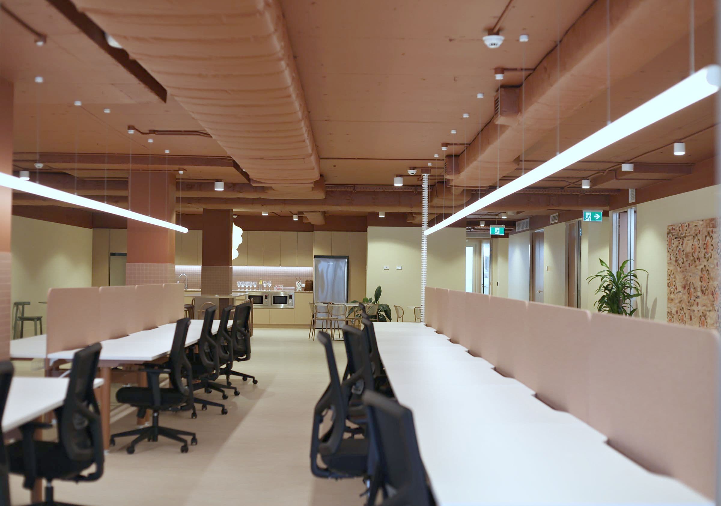 Long rows of open-plan desks leading to the kitchen