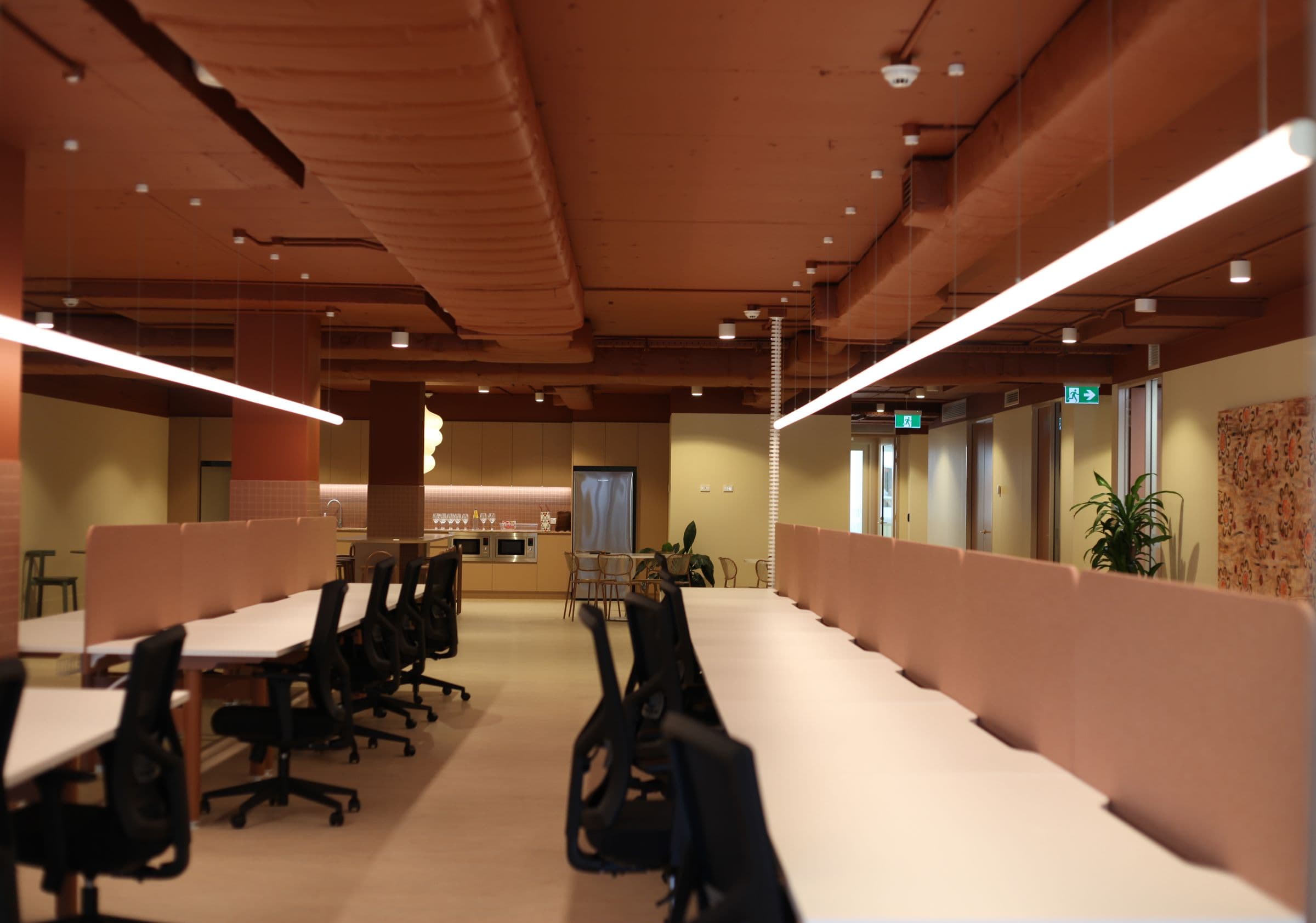 Long rows of open-plan desks leading to the kitchen